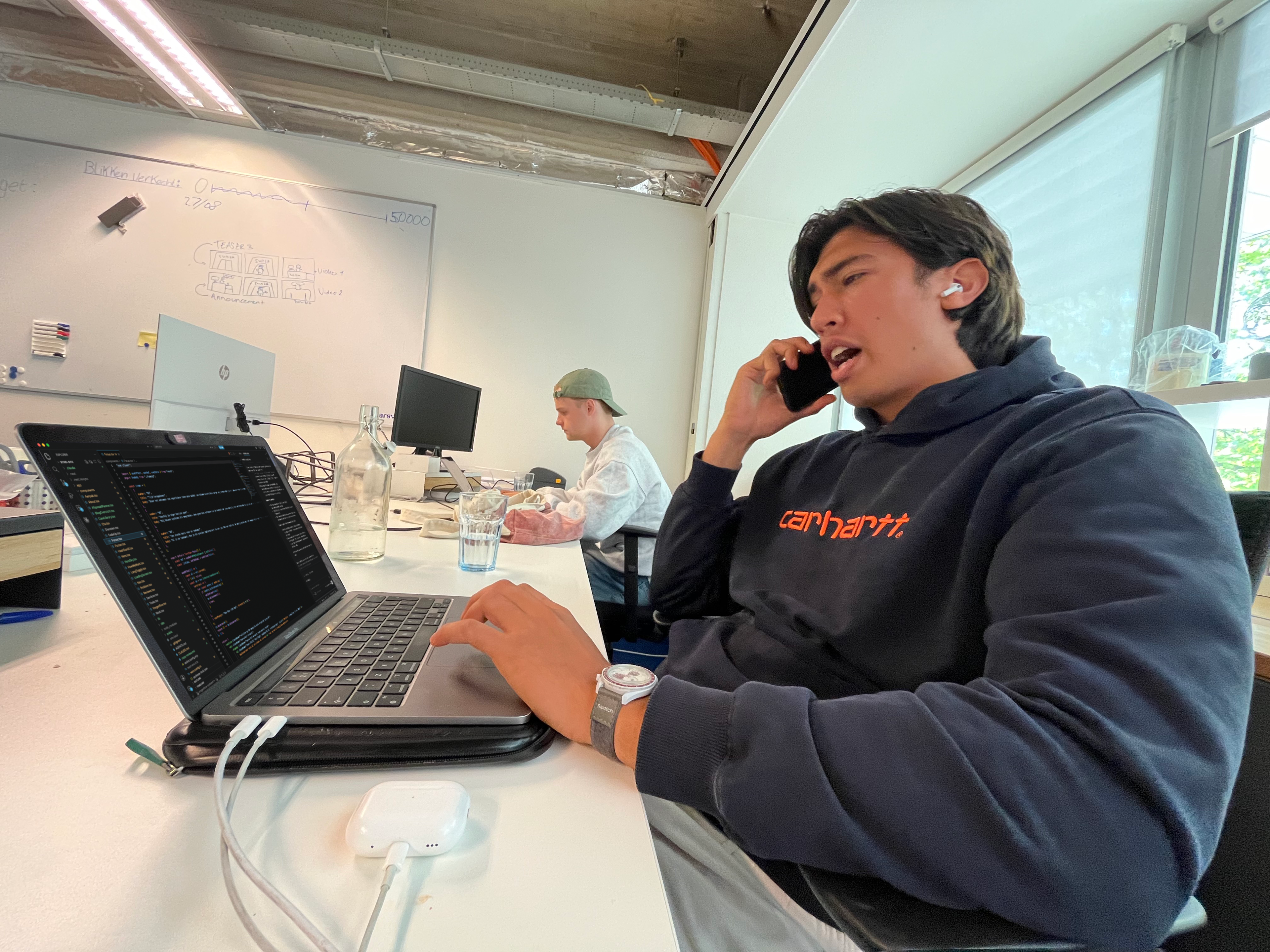 Teamlid van bynd. aan de telefoon achter een laptop op kantoor.